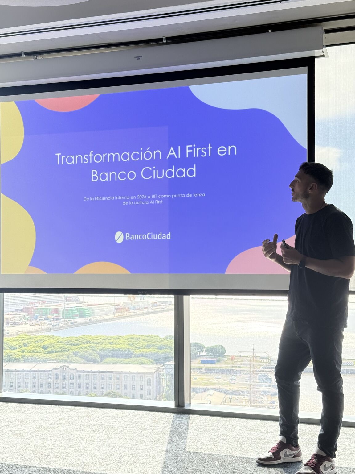 Matias Venutolo presenting in front of a screen reading AI First Transformation at Banco Ciudad